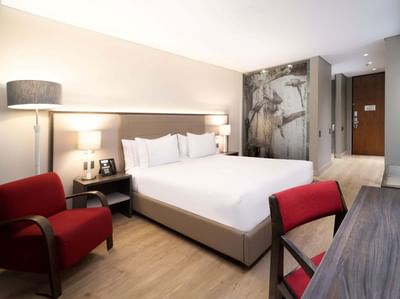 Work desk and seating area by the bed in Superior Queen Room at Habitel Prime Hotel, offering stylish accommodation in Bogota