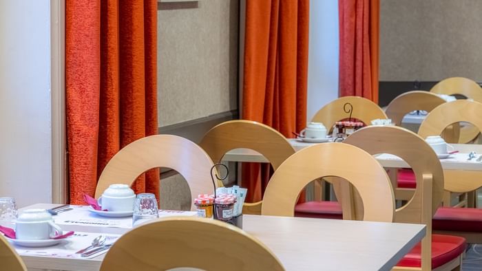 Dining table arrangement in restaurant at The Originals Hotels