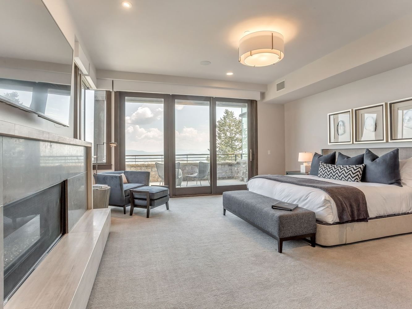 Bedroom with a king bed featuring TV & fireplace in Platinum Room at Stein Eriksen Residences