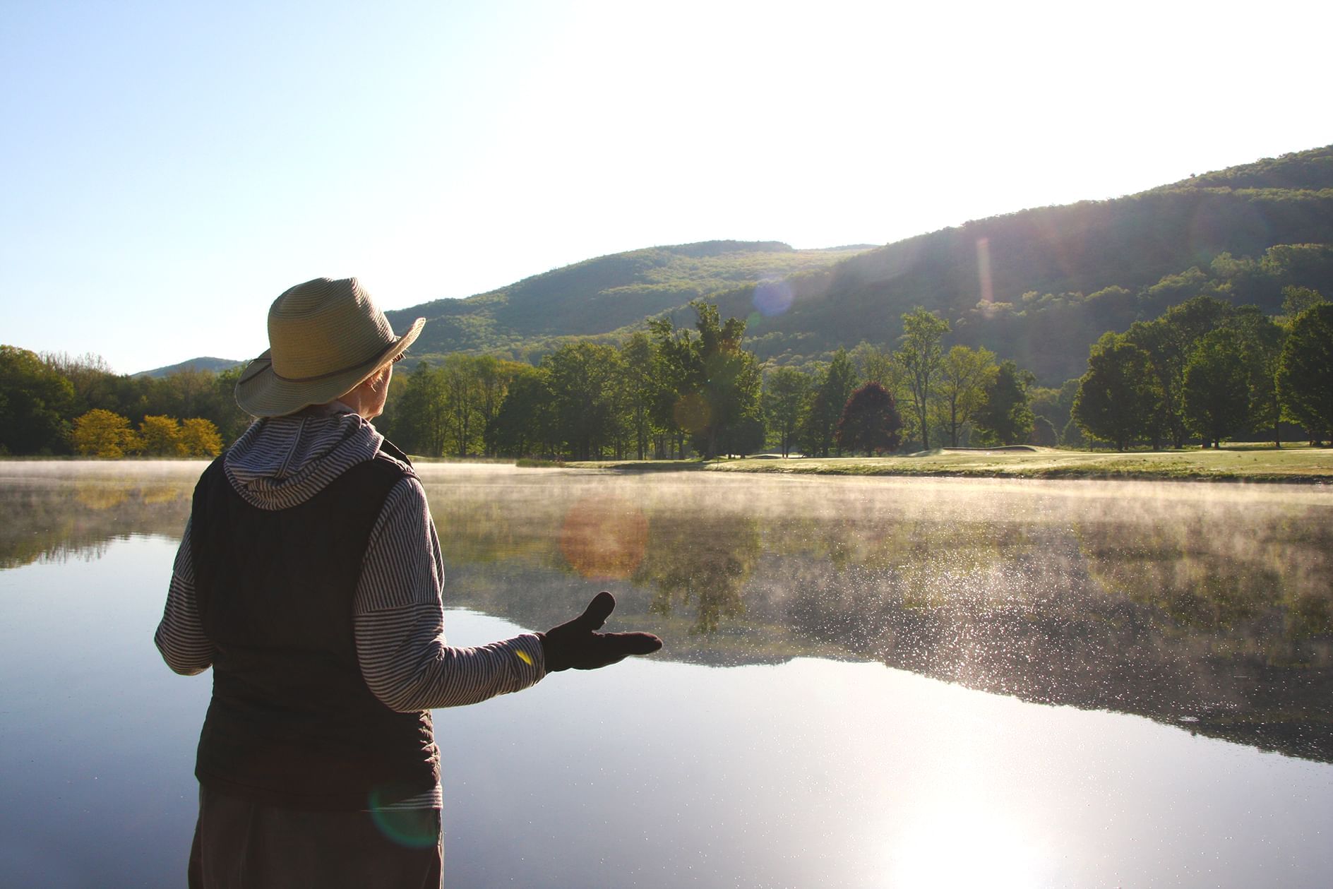 A woman standing by the lake near Honor’s Haven Retreat
