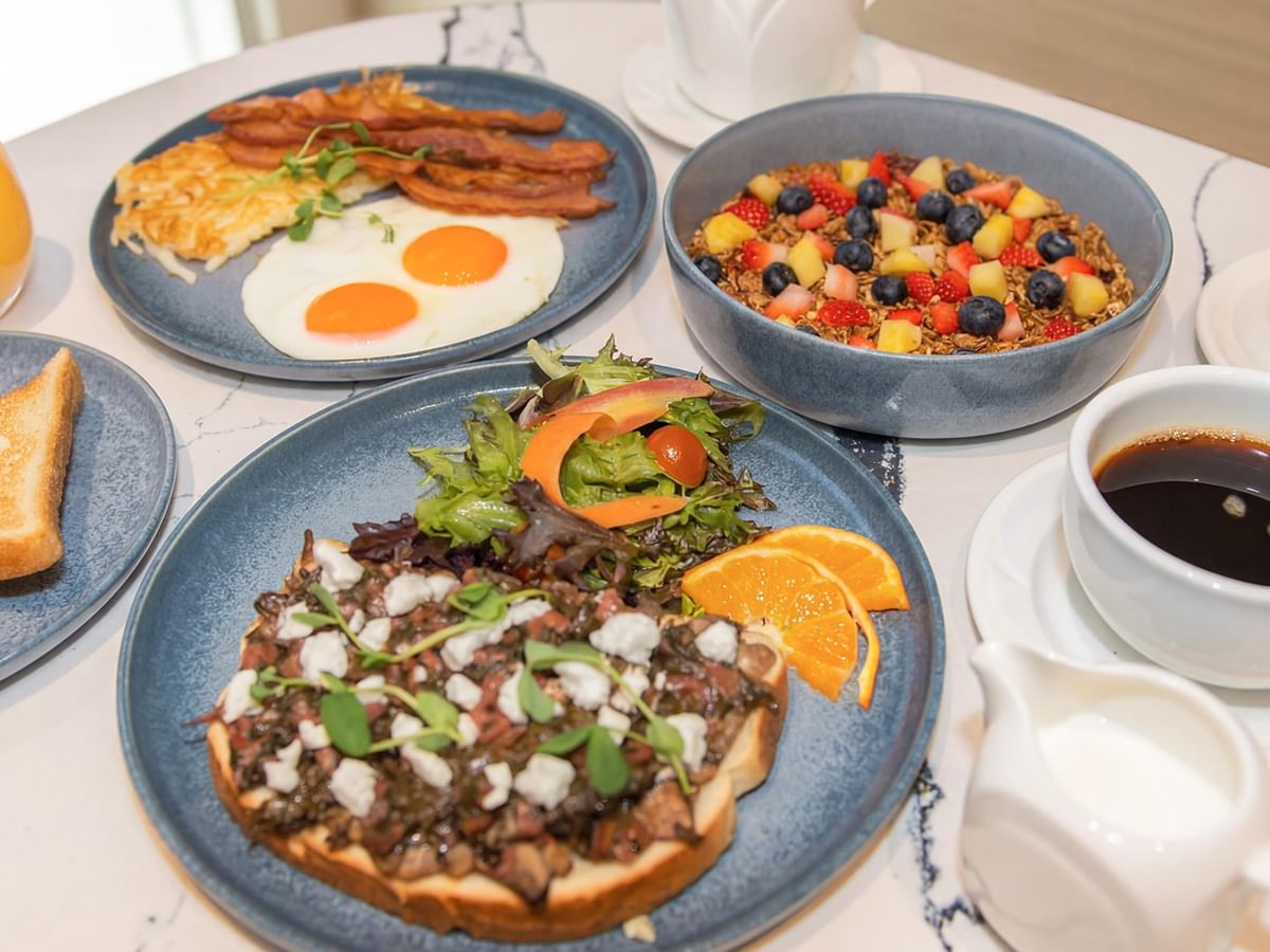 Plates of breakfast dishes and coffee cups.