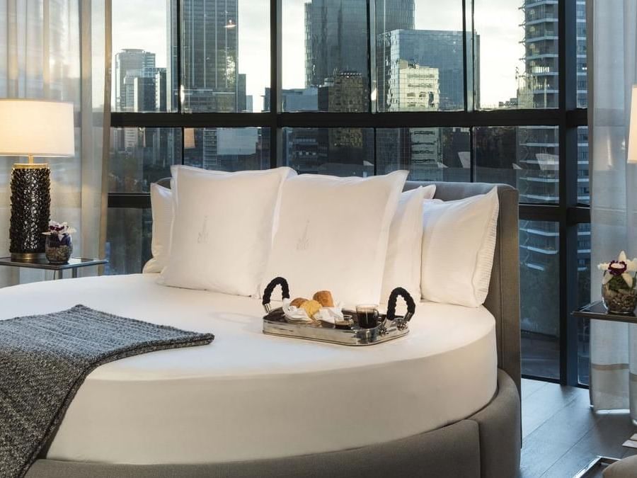 Suite Marquis con cama redonda, mesas con lámparas y vista a la ciudad en Marquis Reforma de Ciudad de México.