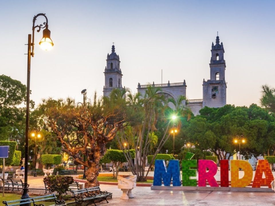 Artistas con vestidos coloridos sobre una carroza de desfile cerca de Camino Real Hotels