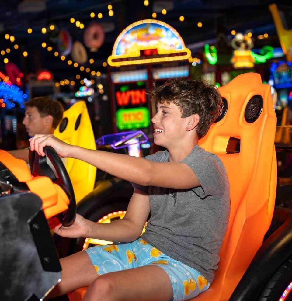 Boys playing arcade racing in Lucky Snake Arcade & Sports Bar at Showboat Hotel & Resort