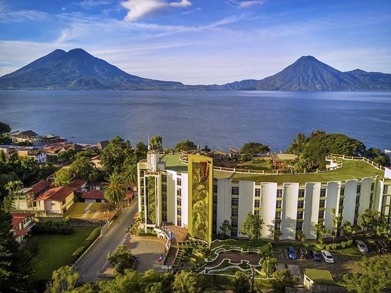 Ariel view of the hotel, mountain and lake at Porta Hotel del Lago