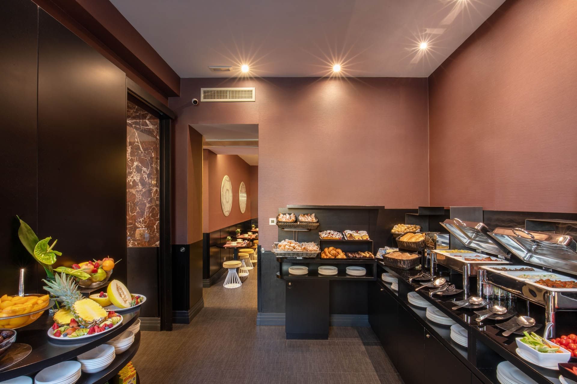 Stylish Breakfast buffet at The Guardian Hotel with fresh fruits, pastries, sleek black furniture, and soft lighting
