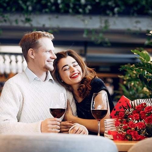 a woman hugging her fiance while drinking wine