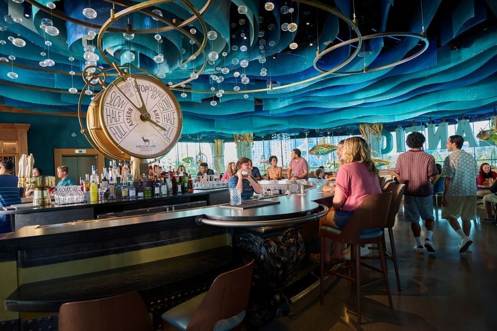 A bar with a blue layered ceiling made to look like underwater waves, complete with hanging bubbles. 