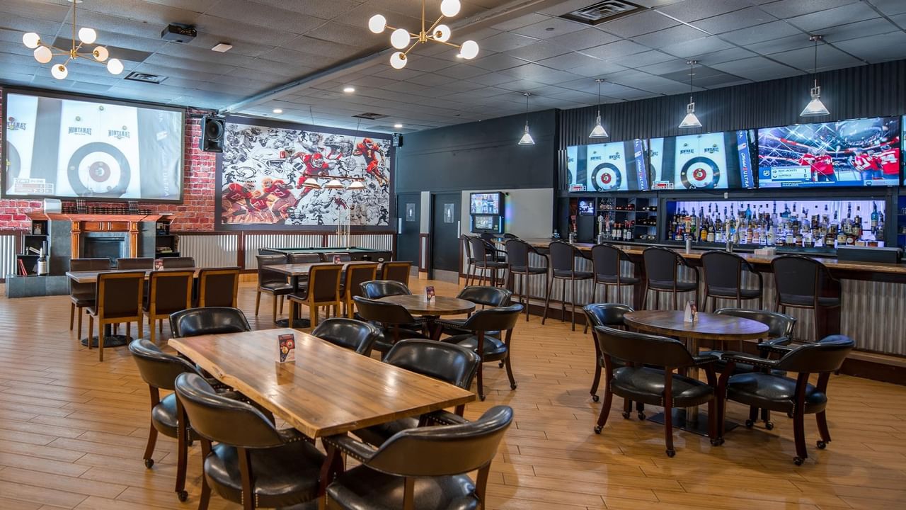 The Den's dining area with bar and multiple dining tables.
