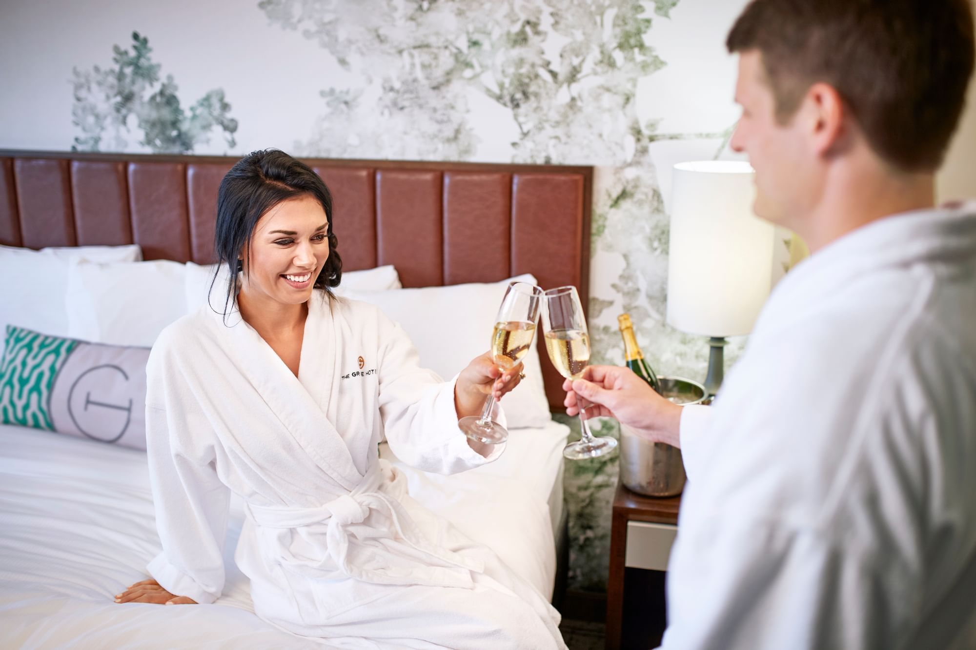 Couple toasting champagne glasses in a room at The Grove Hotel