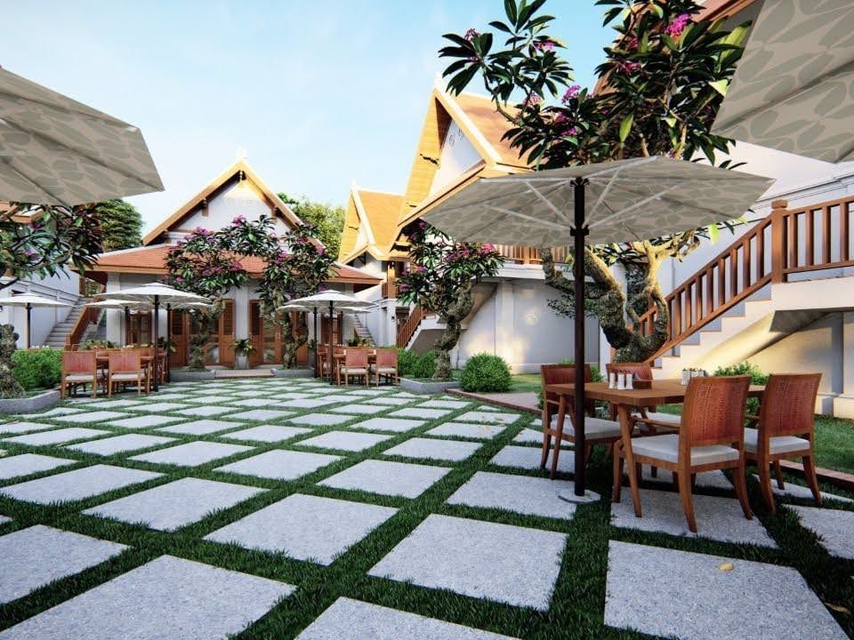 Outdoor seating with umbrellas on a patterned patio at U Luang Prabang