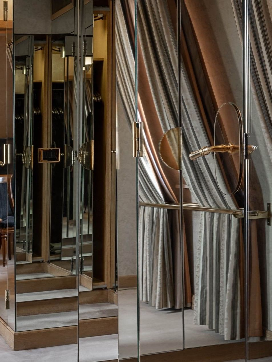 Mirrored closet doors placed by draped floor-to-ceiling curtains in Royal Suite at Warwick Grand Place Brussels