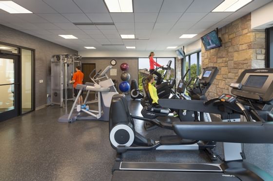 Modern fitness center with cardio equipment, exercise balls, and guests working out at Aramark Chauncey Conference Center