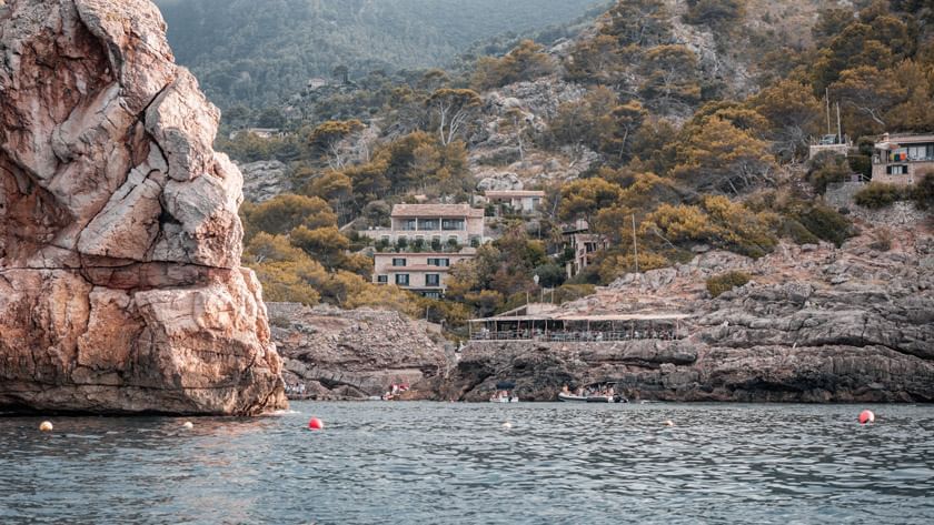 Charmantes Dorf Cala namens Deia, das zwischen grünen Hügeln und dem blauen Mittelmeer liegt