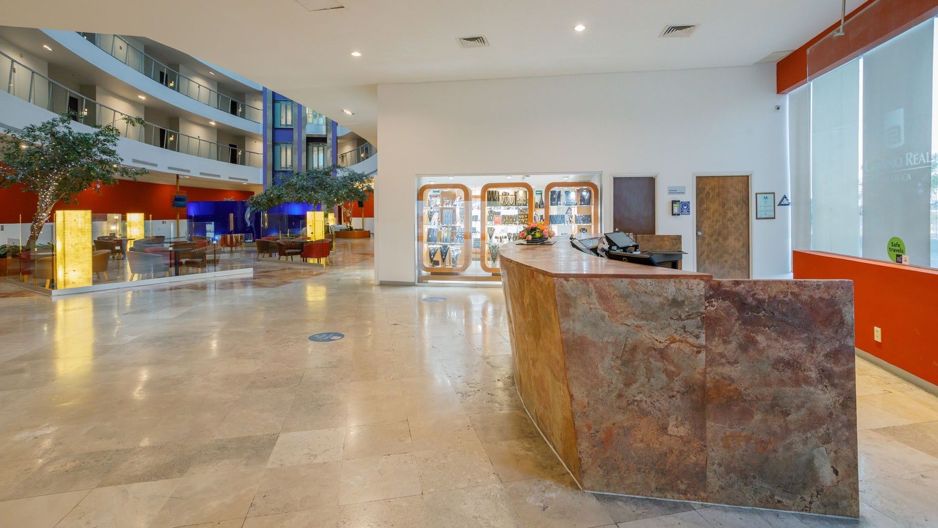 Elegant lobby at Camino Real Pachuca featuring a stone reception desk and a bright, open-plan interior