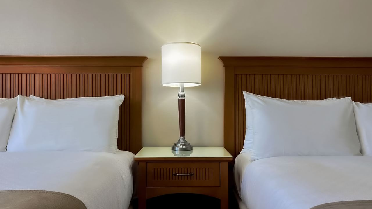 Two queen beds, pillows and lamp