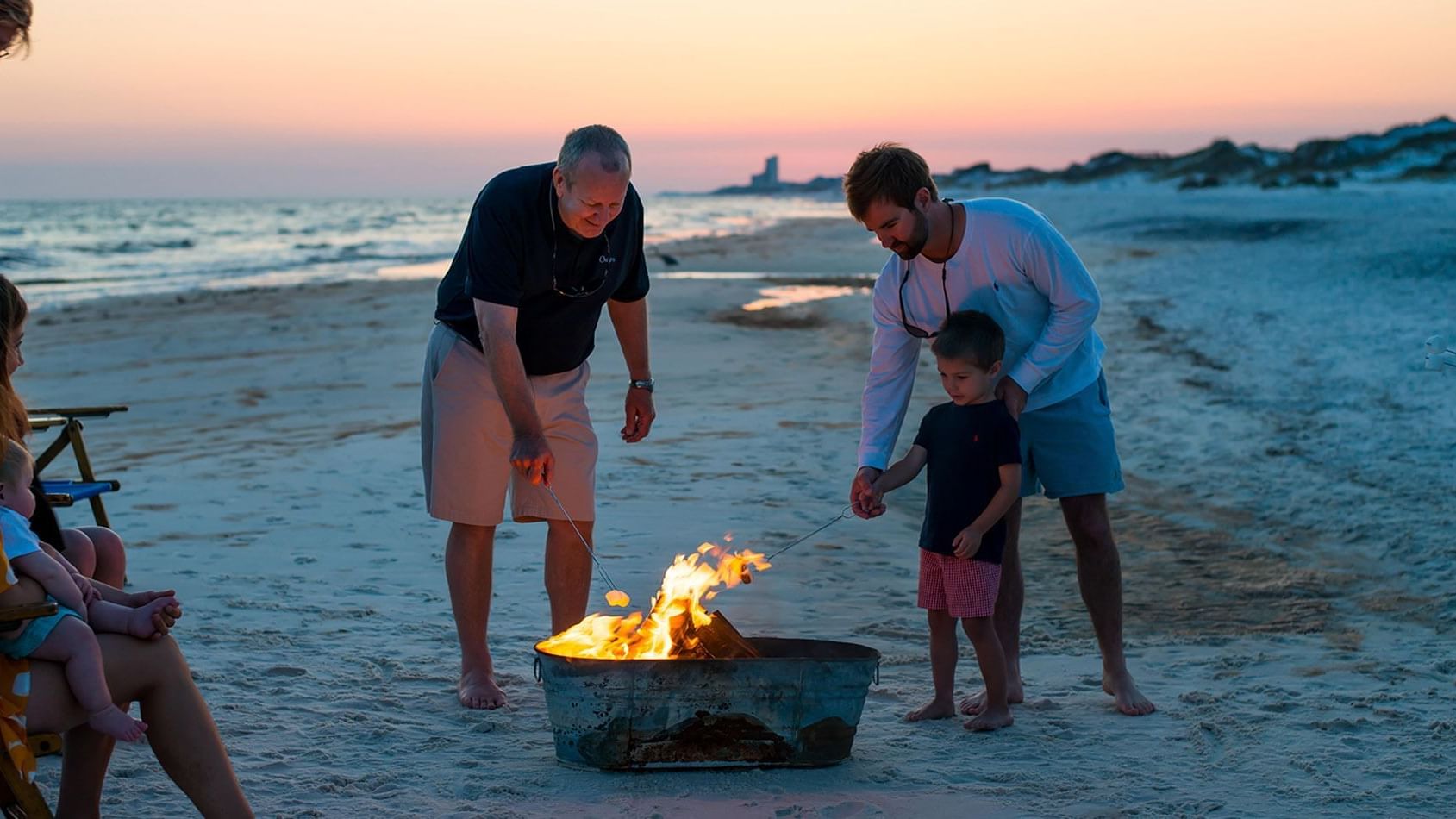 Family enjoying a fire pit on the beach at Watersound Inn