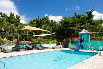 An outdoor swimming pool & lounge at True Blue Bay Hotel