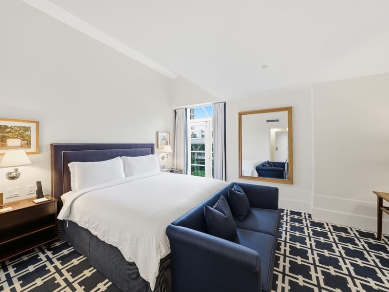 Grand Deluxe Suite with king bed, navy sofa, patterned carpet, and natural light at el PRADO Hotel, Palo Alto