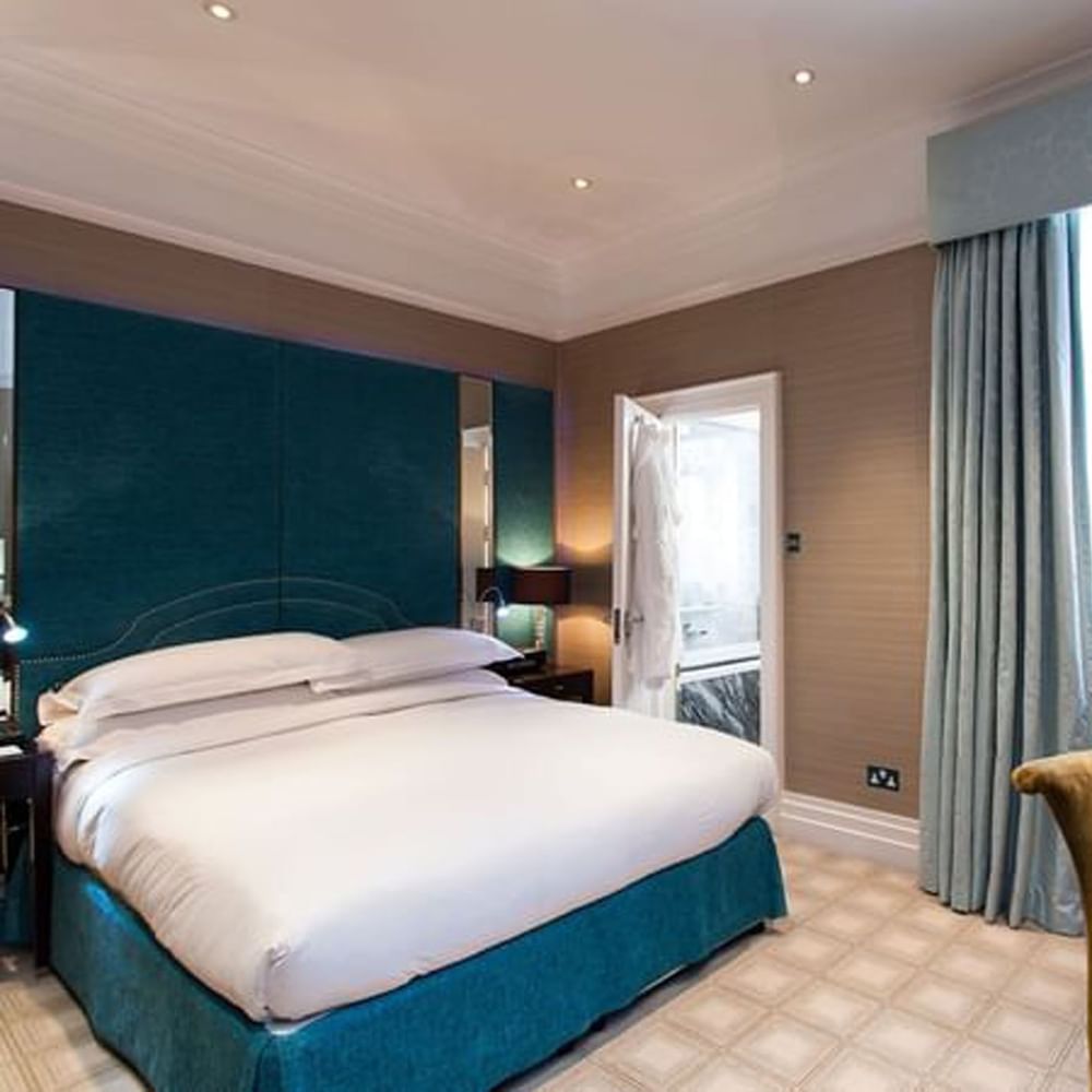 Bed with side tables and working desk near window in Classic Townhouse Room at The Capital Hotel, Apartments and Townhouse