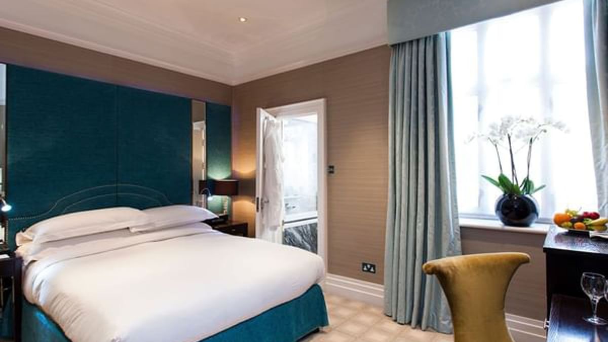 Bed with side tables and working desk near window in Classic Townhouse Room at The Capital Hotel, Apartments and Townhouse