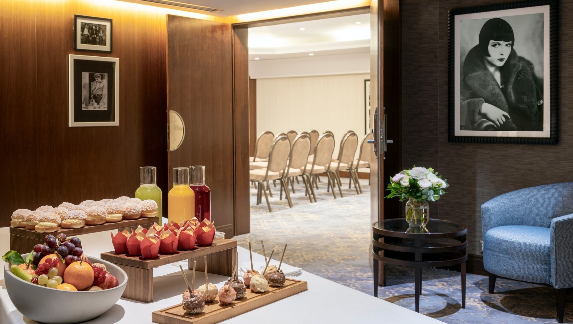 Elegant hotel lounge with fruit bowls and drinks next to a meeting room at Warwick Corporate