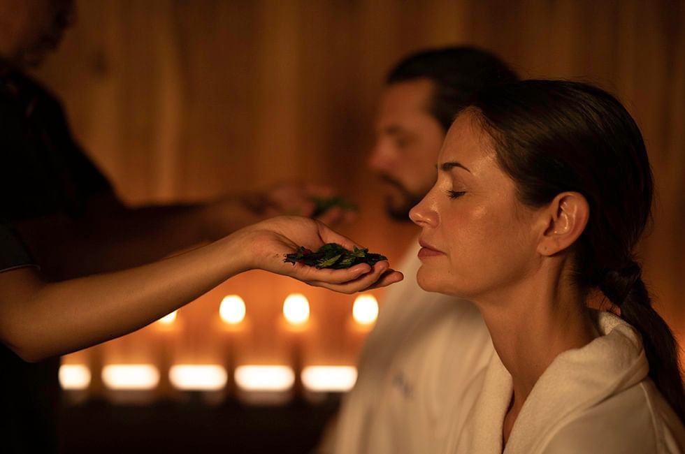 Person in a robe receiving a spa treatment with candles at Live Aqua Resorts and Residence Club