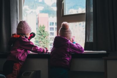 Kids looking outdoor through a window at Aava Whistler Hotel