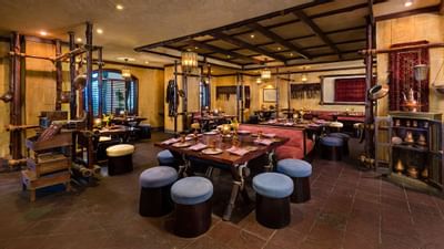 A restaurant with round chairs & tables at Hotel Ajman