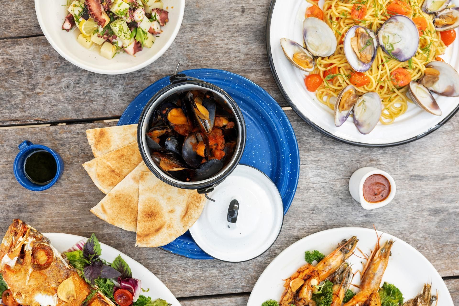 A delicious spread of seafood including mussels clams pasta and grilled fish served at Lulas Kitchen in La Zebra Hotel