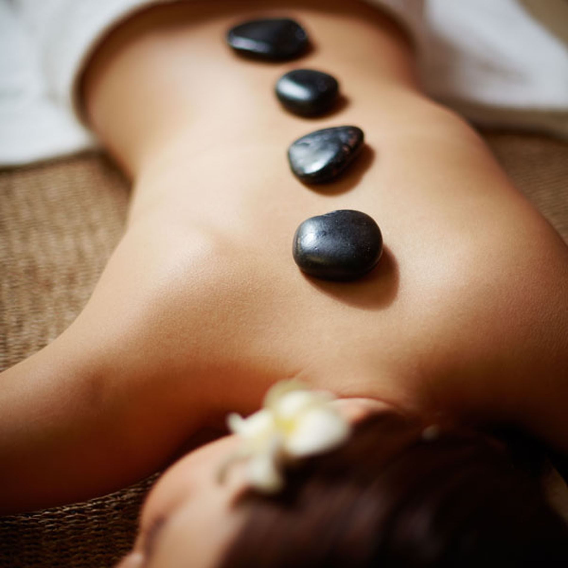 Lady having hot stone massage in Reflection Spa & Salon at Lake Buena Vista Resort Village & Spa