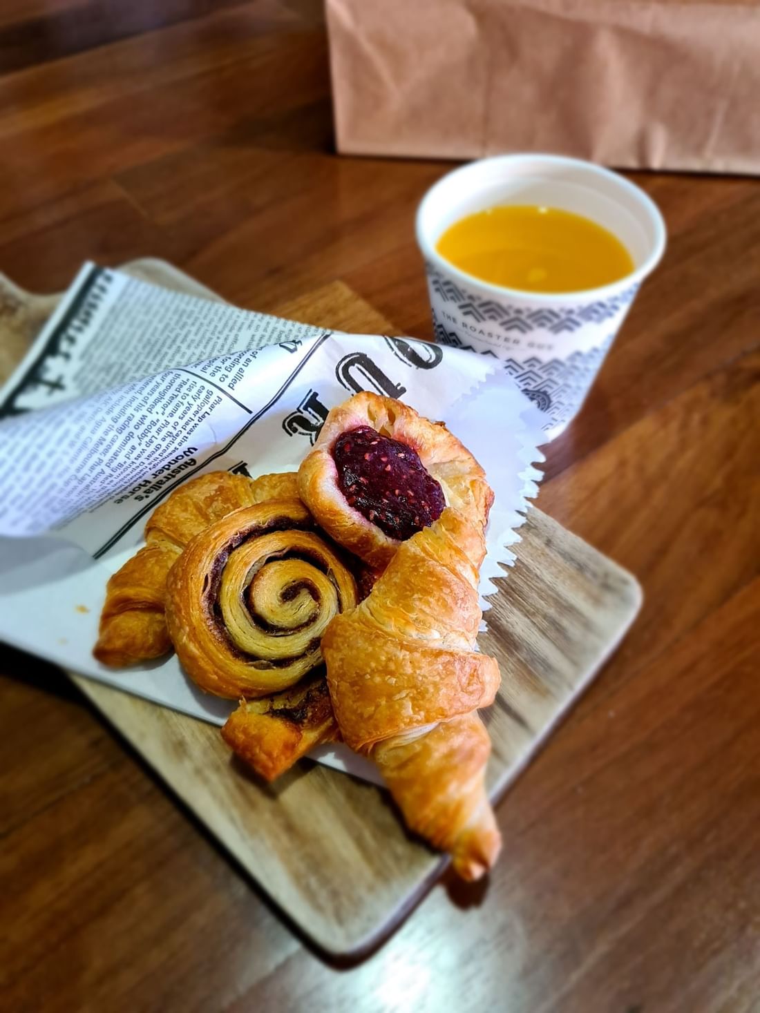 Close-up of delicious pastries and a juice cup on a wooden board served in Ibis Kitchen at Ibis Adelaide