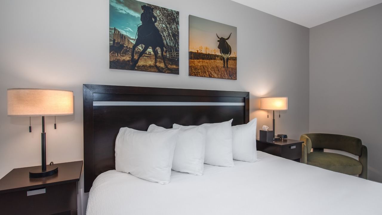 King bed at Coast Innisfail Hotel with bedside lamps and artwork