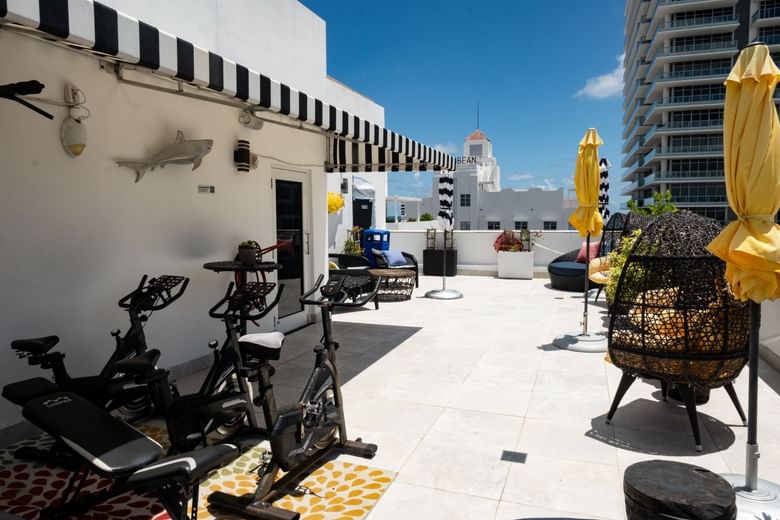 A rooftop gym with exercise bikes and outdoor seating.