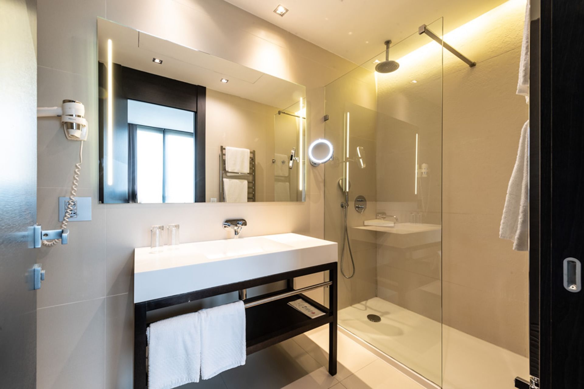 Suite con bagno moderno con doccia in vetro e lavabo bianco presso DUPARC Contemporary Suites