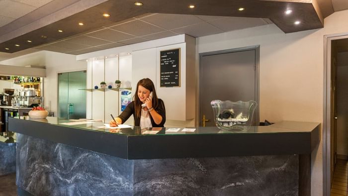 A receptionist at the reception desk in Hotel Mulhouse East