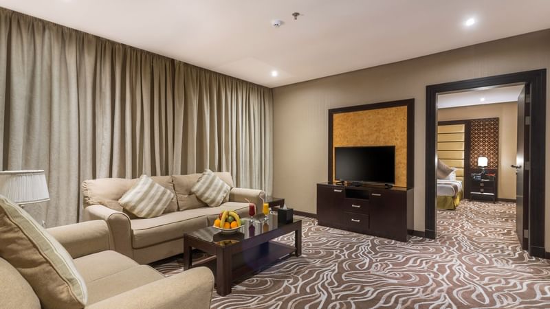 Junior Suite living area with an open door leading to the bedroom at Warwick Al Khobar