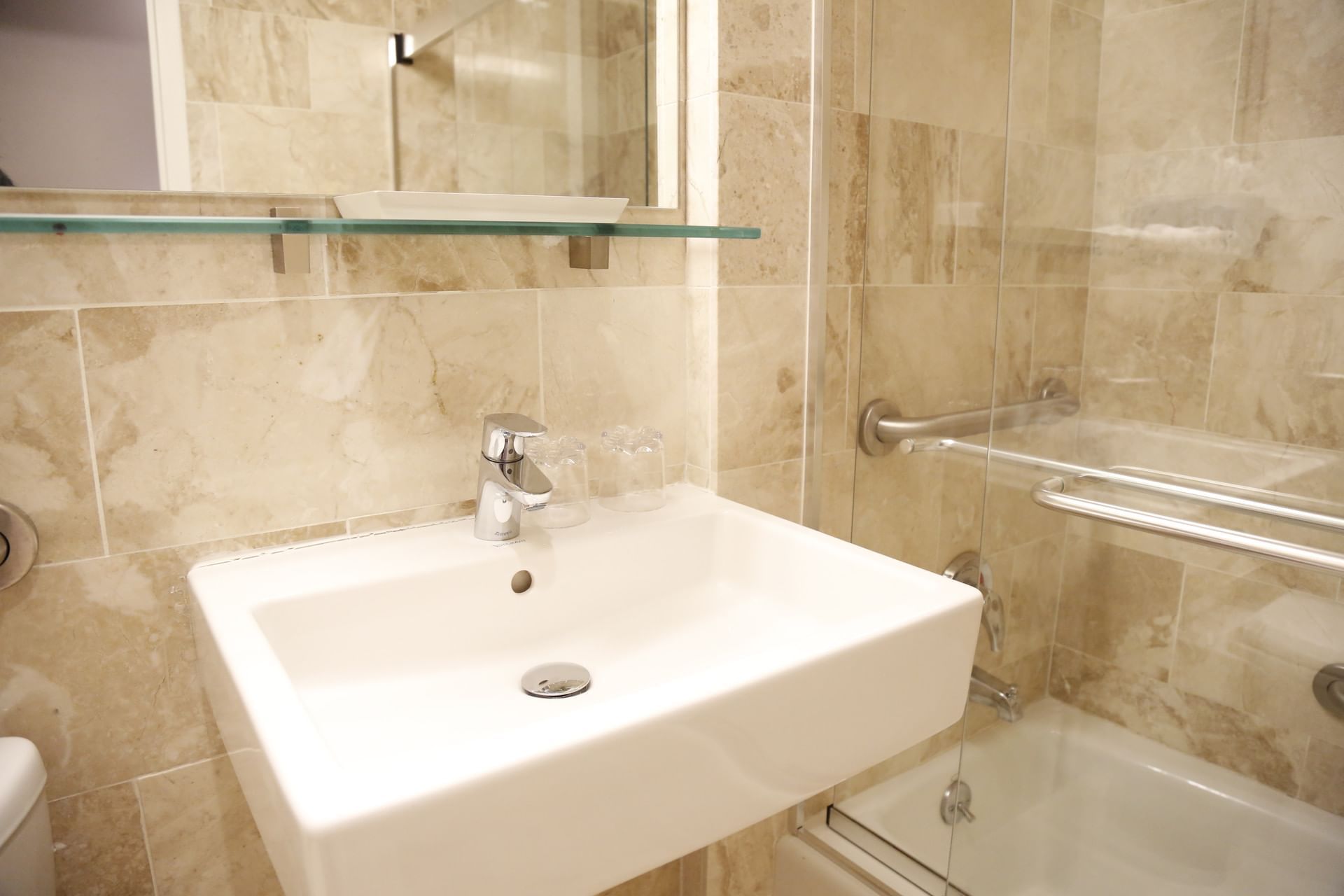 A bathroom with a sink, mirror, shower, and bathtub