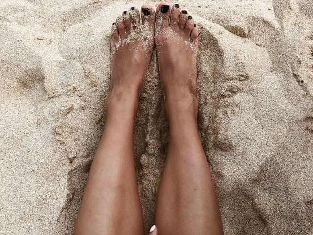 Womens feet in the sand