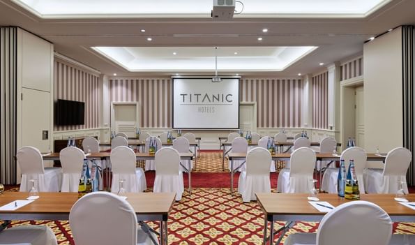 Tables arranged in front of the projector in Private Meeting Room I+II at Titanic Gendarmenmarkt Berlin