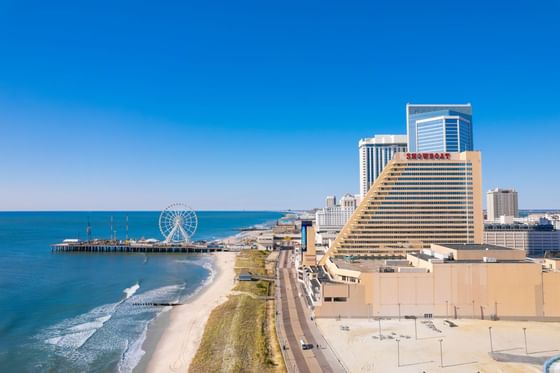 Aerial view of beachfront hotel towers and boardwalk with ferris wheel along the Atlantic Ocean at Showboat Hotel & Resort Atlantic City