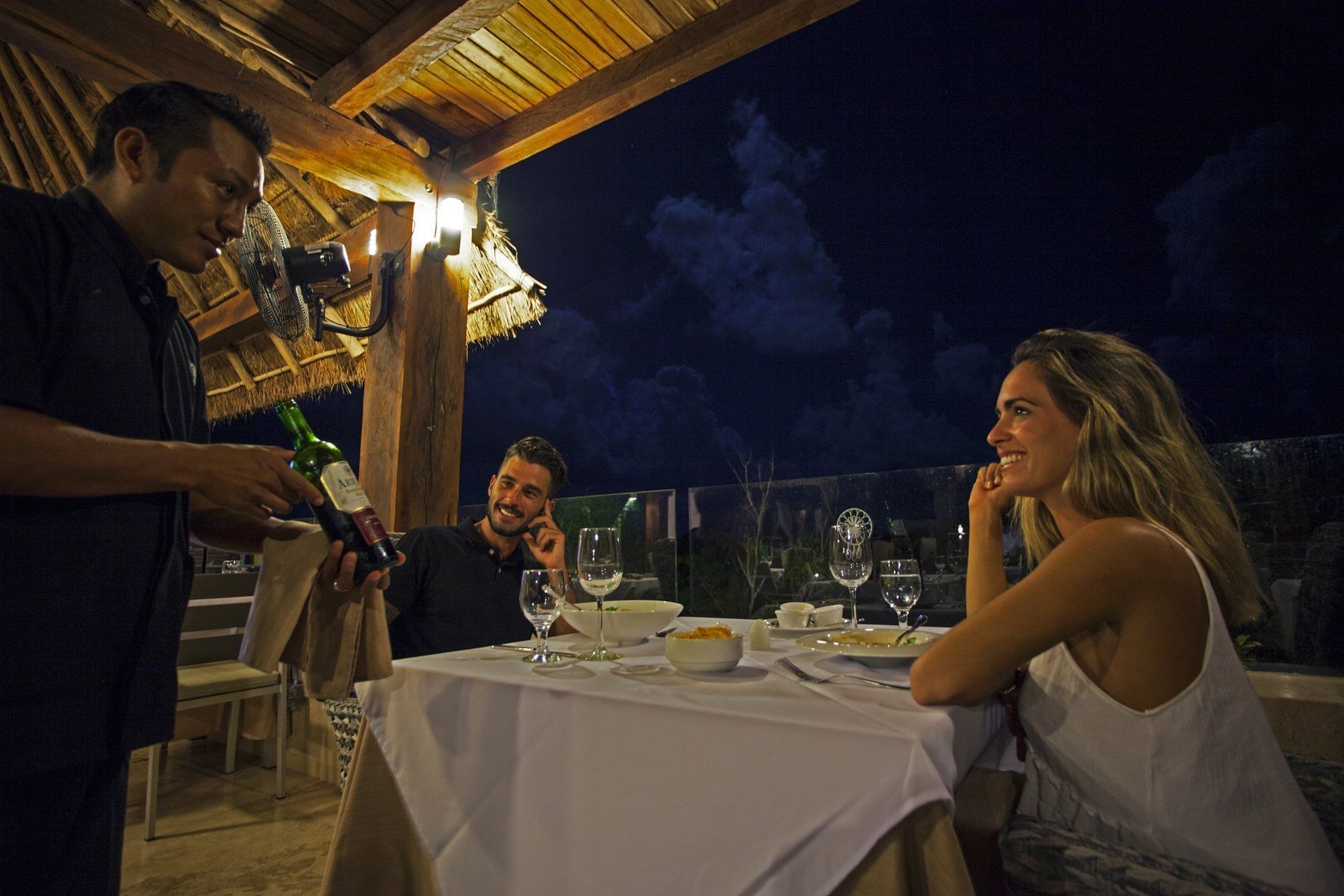Serving wine to a couple at Naay Tulum Curamoria Collection