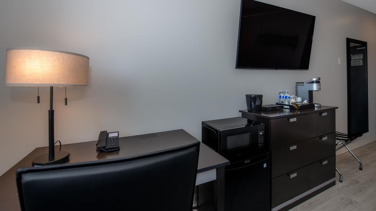 Guest room at Coast Innisfail Hotel with desk, TV and dresser