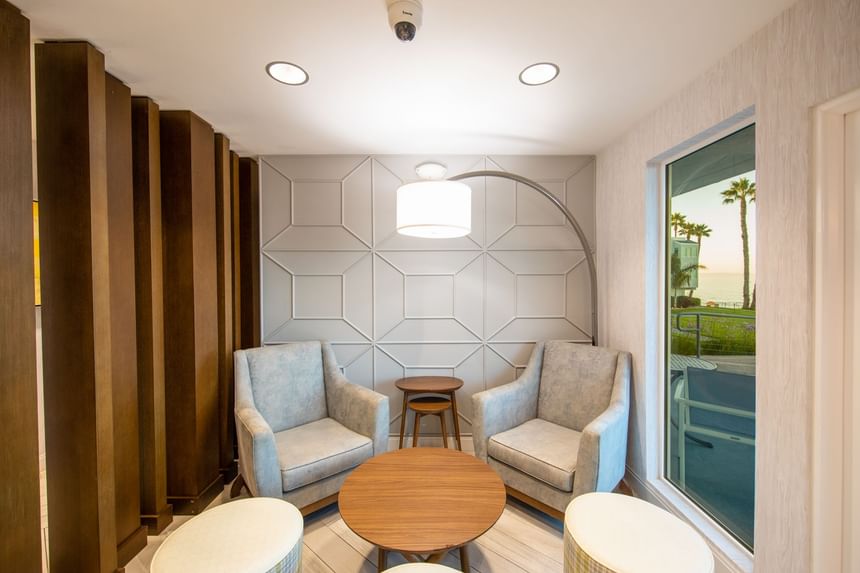 Hotel lobby seating area with two chairs, tables and lamps