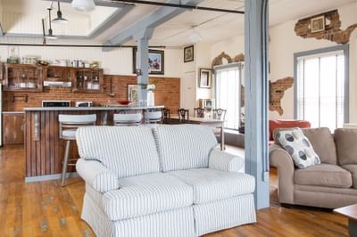 Living area with cozy sofa, bar counter & dining table in Apartment 405 at Retro Suites Hotel