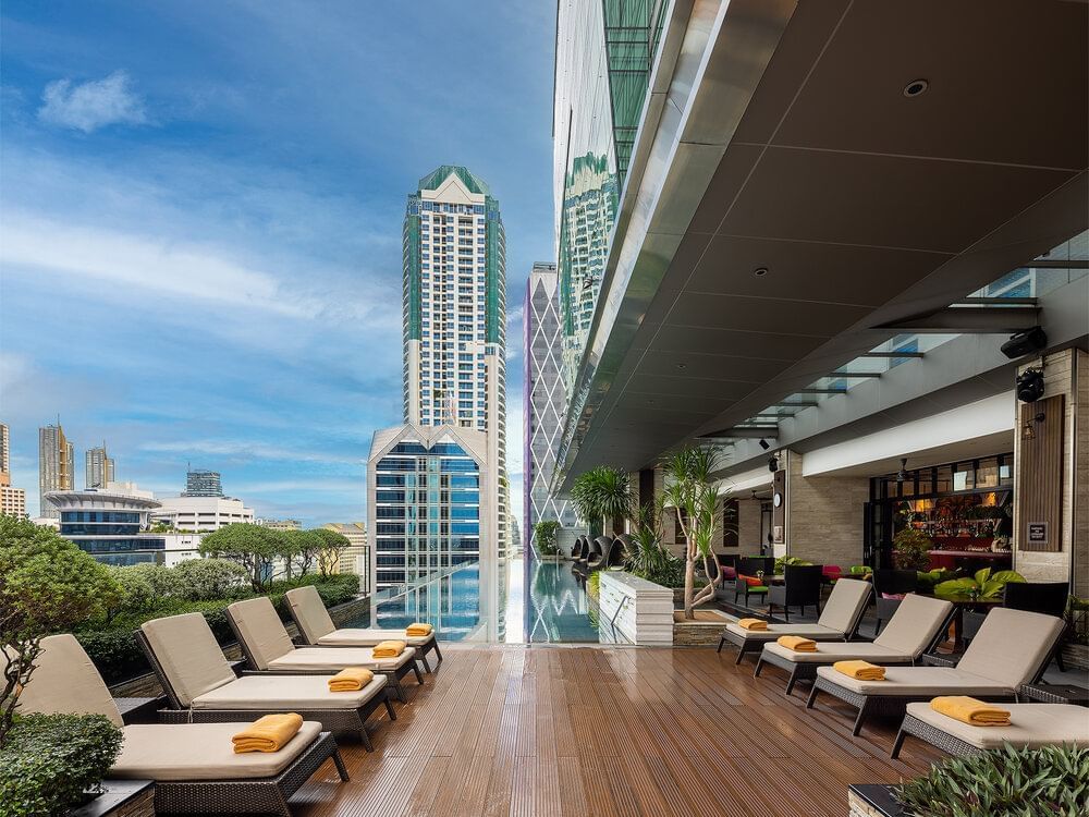Swimming area with pool loungers at Eastin Grand Hotel Sathorn