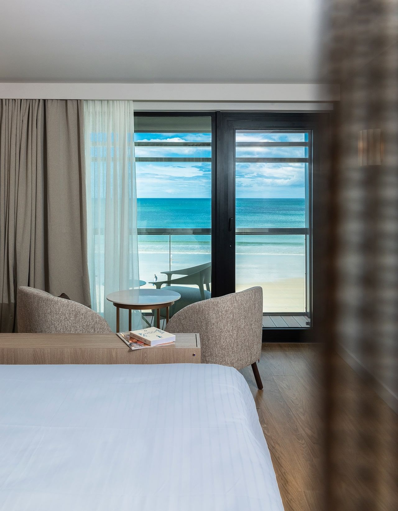 Intérieur et décoration d'une chambre avec coin salon et vue sur l'océan à l'Oceania Saint-Malo