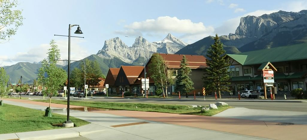 A road through Canmore with the mountains in the distance.