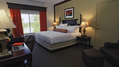 king bed with white sheets next to window