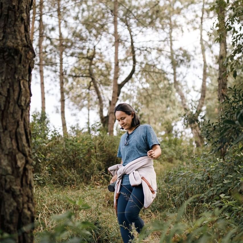 Women walking in the forest with a jacket tied around the waist near The Terraces Resort & Spa